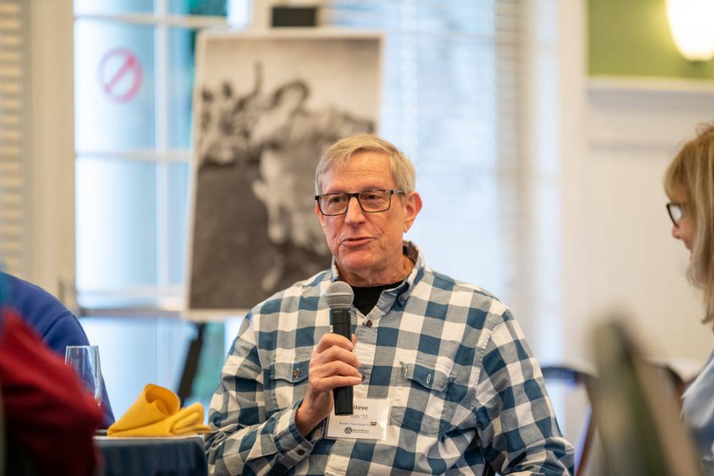 An alumni speaking to the audience.